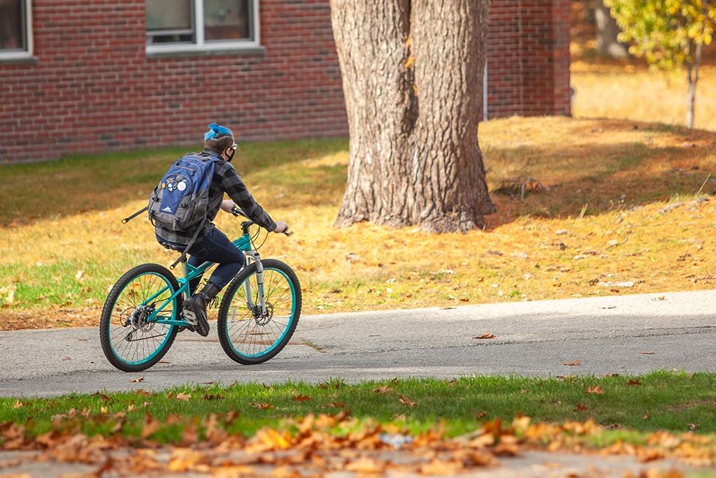 一名英国东北大学的学生骑着自行车穿过比德福德校园